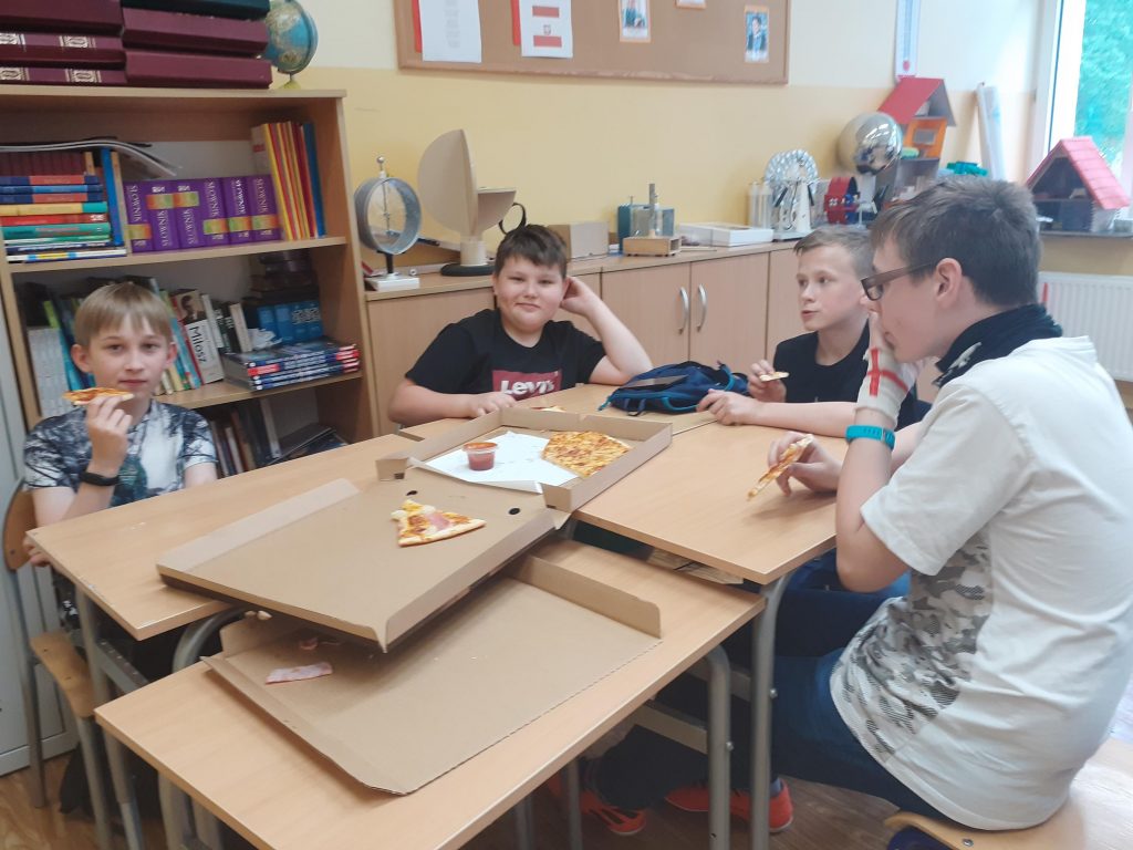 Uczniowie klasy szóstej w trakcie zajadania pizzy