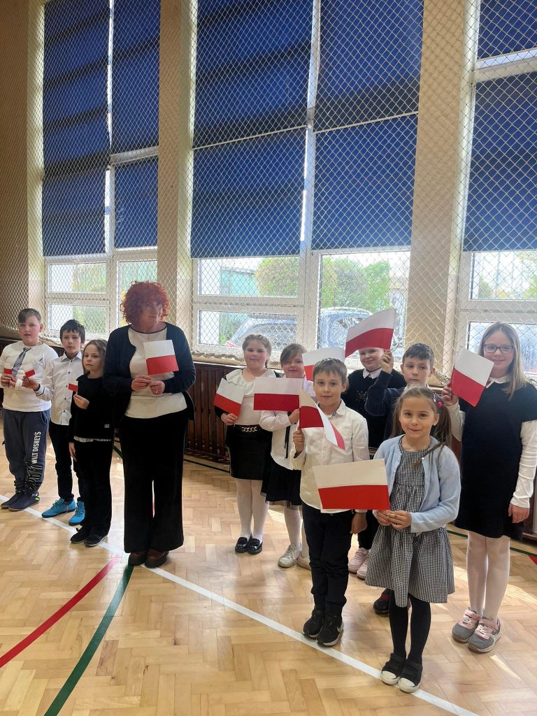 Uczniowie klasy drugiej i czwartej prezentują symbole narodowe Polski